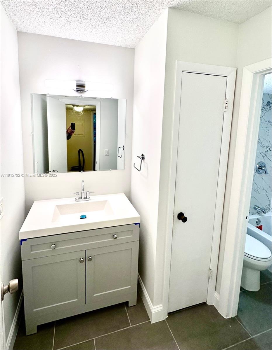 4561 West McNab Road, Unit 16 Pompano Beach, FL 33069 - Photo 5 of 14 a bathroom with a double vanity sink and a mirror