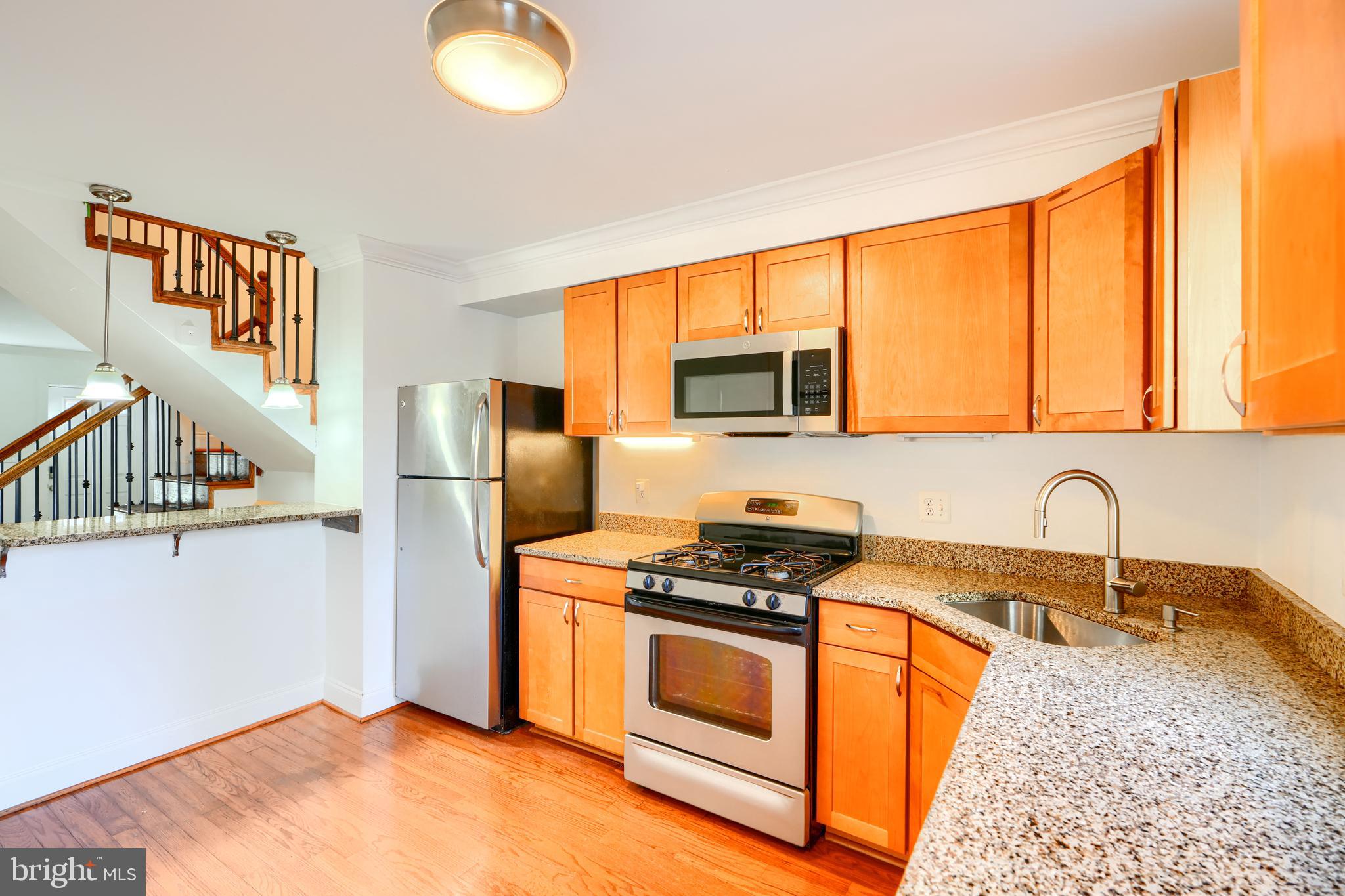 1520 Byrd Street Baltimore, MD 21230 - Photo 9 of 36 a kitchen with stainless steel appliances granite countertop a stove a sink and a microwave