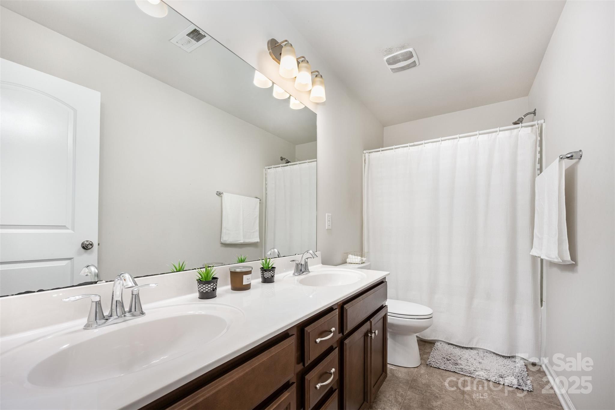 6883 Spring Peeper Lane Lancaster, SC 29720 - Photo 21 of 42 a bathroom with a double vanity sink mirror and toilet
