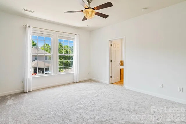 an empty room with windows and fan