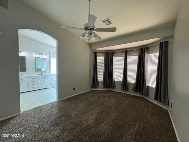 a view of a hallway with a chandelier fan and windows