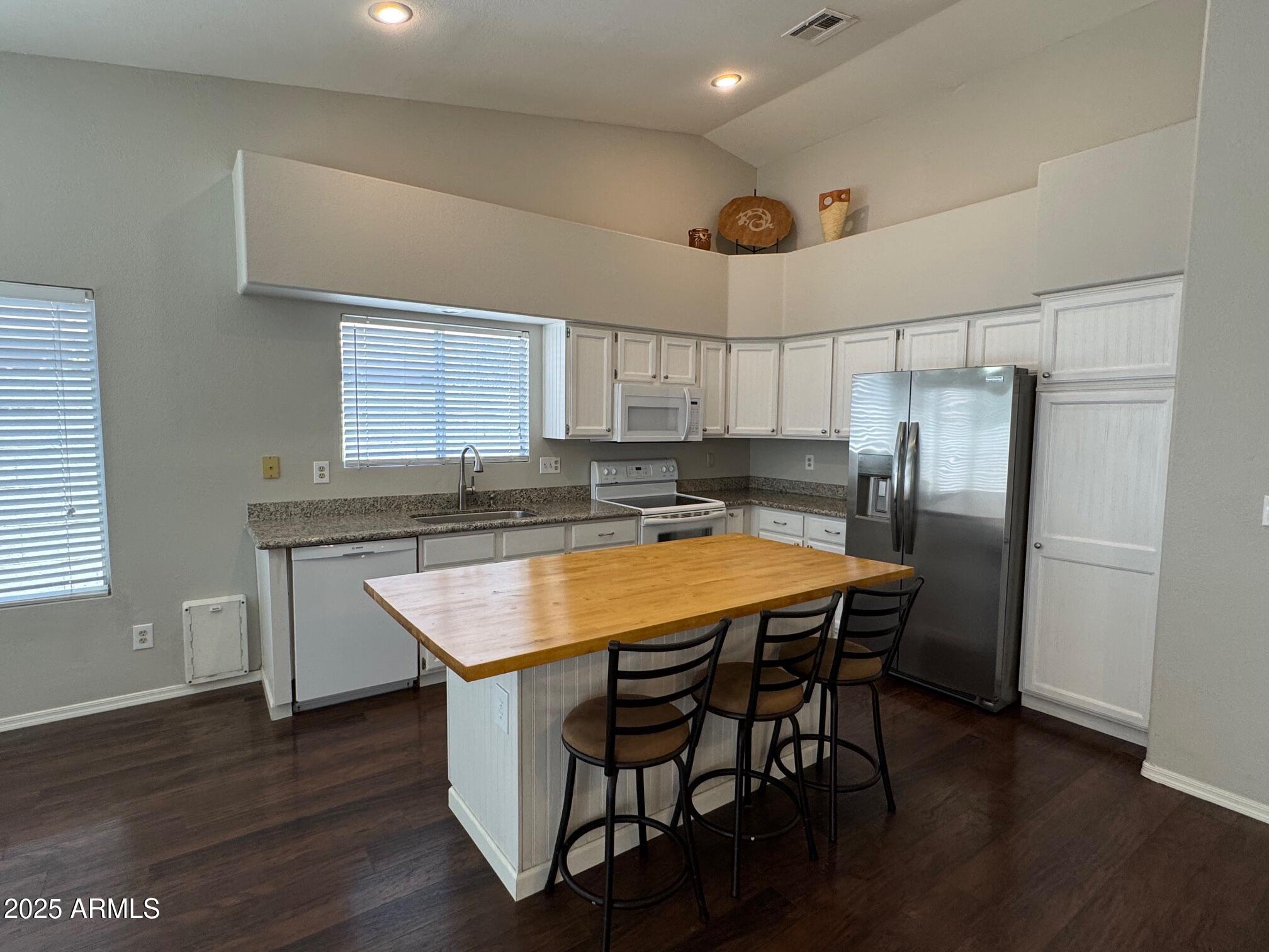 1822 South 39th Street, Unit 6 Mesa, AZ 85206 - Photo 3 of 18 a kitchen with stainless steel appliances granite countertop a refrigerator a sink a stove a dining table and chairs