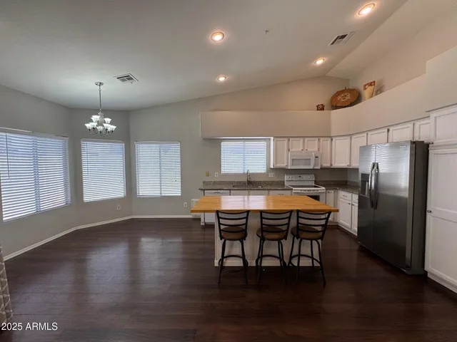 a kitchen with stainless steel appliances granite countertop a kitchen island hardwood floor and a sink