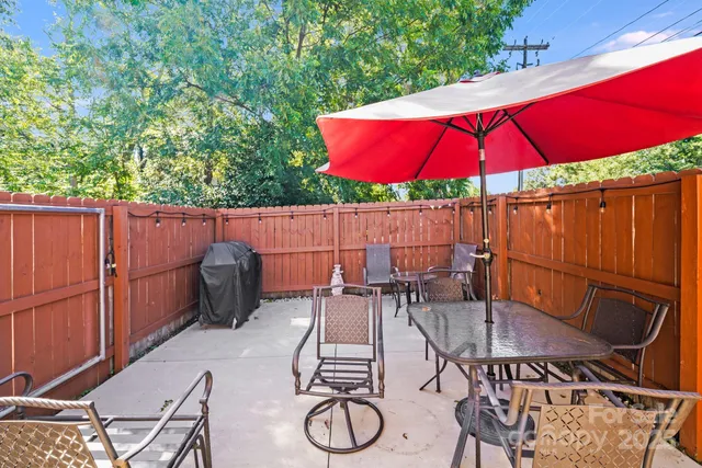 a view of patio with table and chairs under an umbrella
