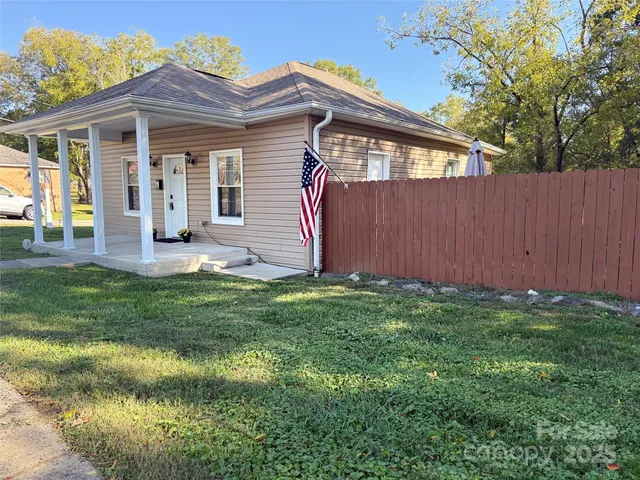 a view of a backyard with table and chairs and wooden fence