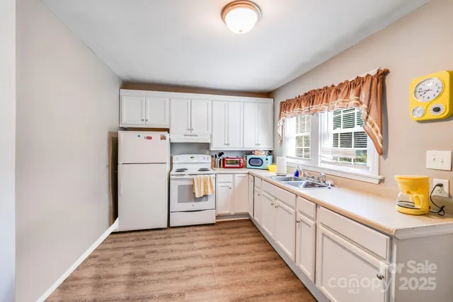a kitchen with appliances cabinets a sink and a window