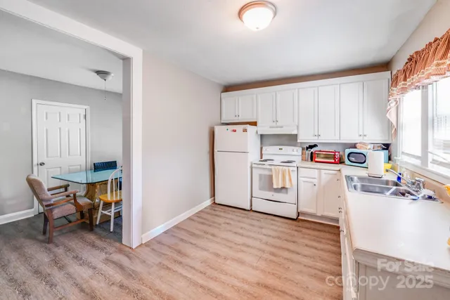 a kitchen with white cabinets and white appliances