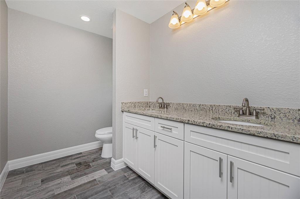 12 Current Lane Placida, FL 33946 - Photo 14 of 16 a bathroom with a granite countertop toilet a sink and a mirror