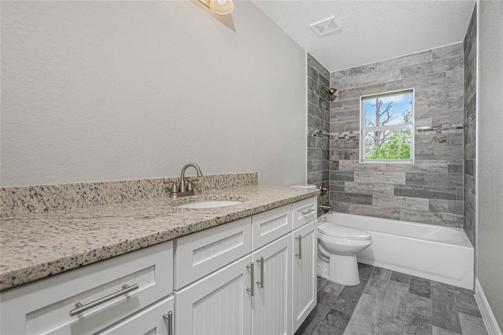 12 Current Lane Placida, FL 33946 - Photo 4 of 16 a bathroom with a granite countertop sink a toilet and bathtub