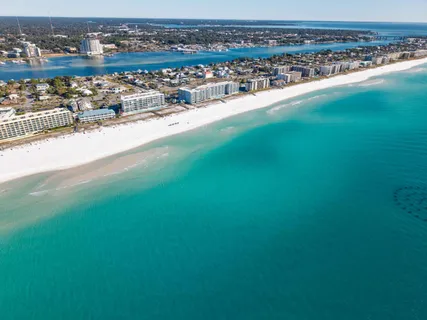 an aerial view of ocean and residential houses with outdoor space
