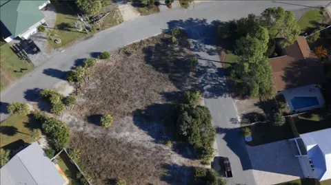 an aerial view of a house with a yard and large trees
