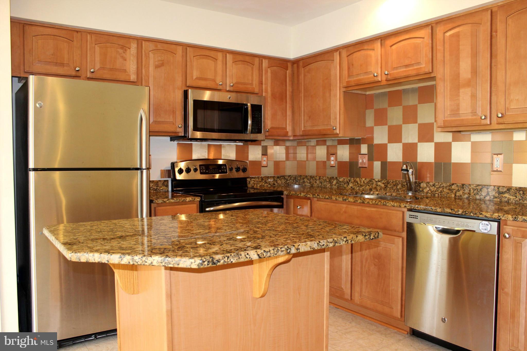 1319 Steed Street Ranson, WV 25438 - Photo 11 of 22 a kitchen with stainless steel appliances granite countertop a refrigerator a stove and a sink with wooden floor