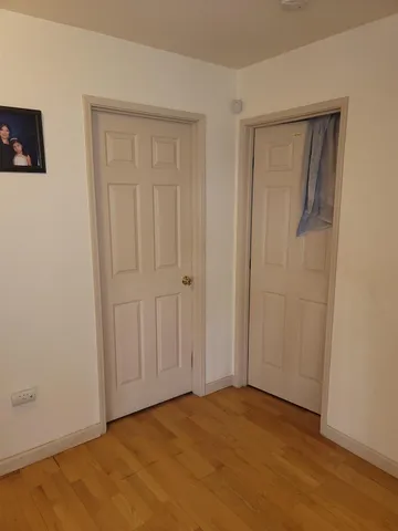 a bedroom with a bed and a flat tv screen on a dresser