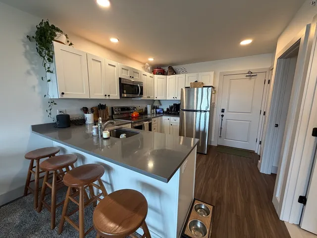 a kitchen with a table chairs refrigerator and microwave
