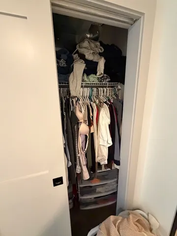 a view of walk in closet with clothes and shoes