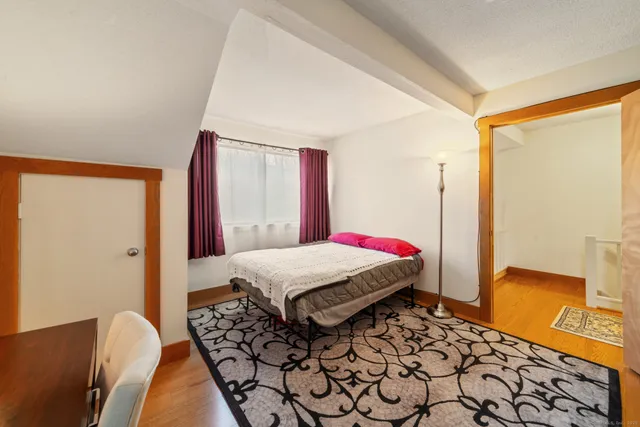 a bedroom with a bed and dresser with mirror