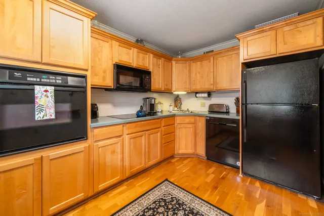 a kitchen with stainless steel appliances granite countertop a refrigerator a stove and a microwave