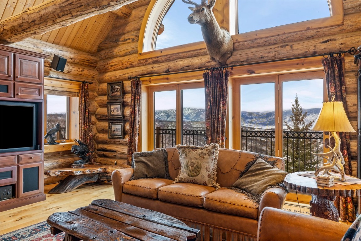 32790 Hidden Pond Path Steamboat Springs, CO 80487 - Photo 6 of 31 a living room with furniture a flat screen tv and a floor to ceiling window