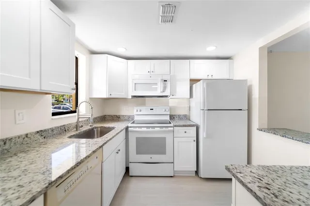 a kitchen with a refrigerator sink stove and cabinets