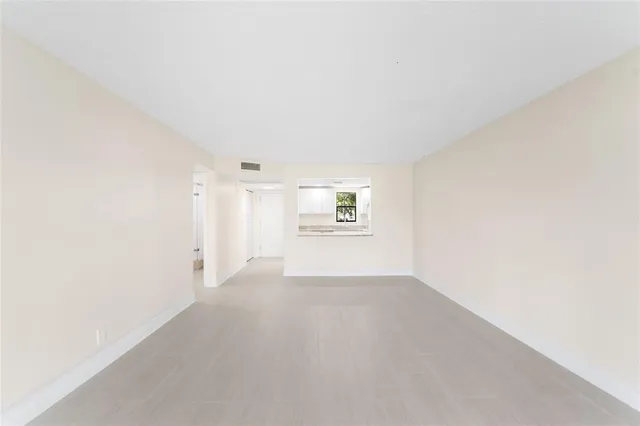 a view of a big room with wooden floor and windows