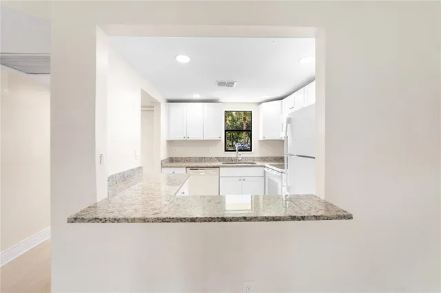 a view of a kitchen with kitchen island sink and refrigerator