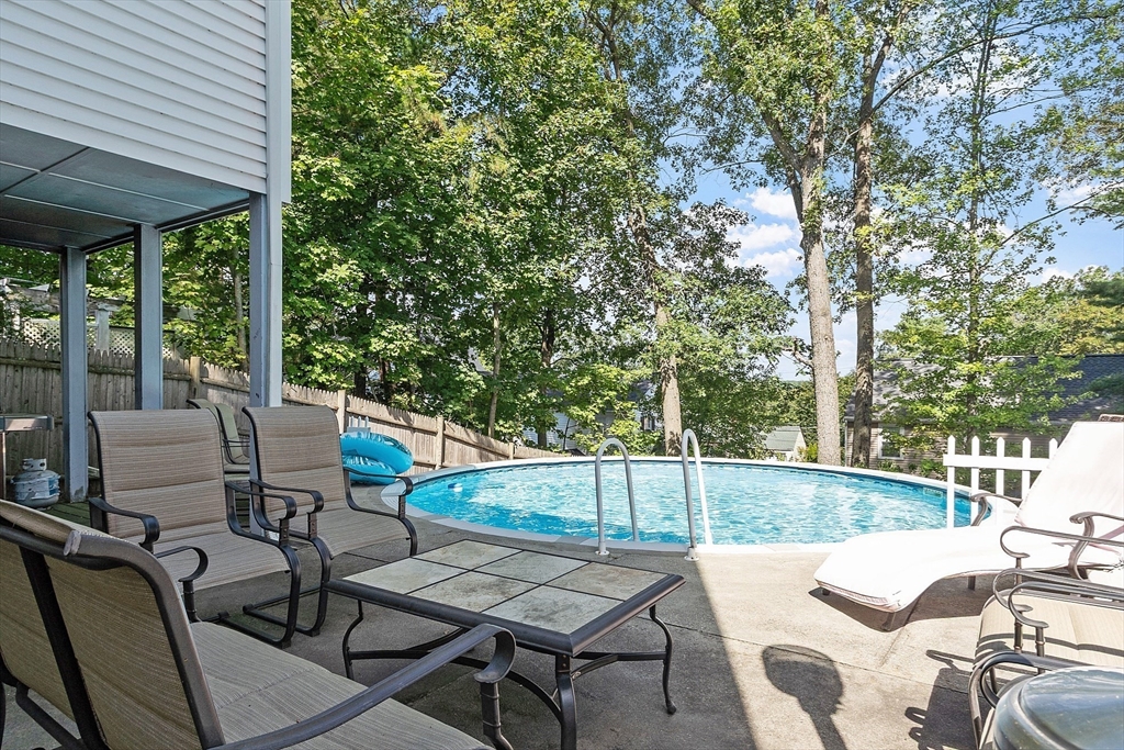 145 Virginia Road Waltham, MA 02453 - Photo 29 of 36 a view of a patio with chairs and table under an umbrella