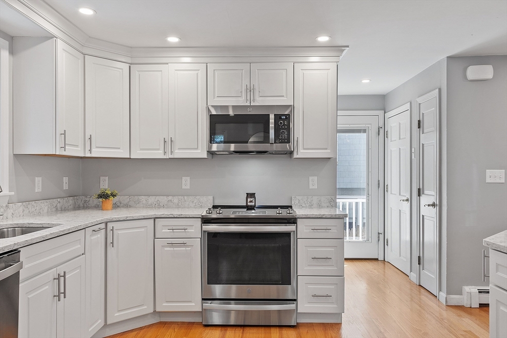 145 Virginia Road Waltham, MA 02453 - Photo 6 of 36 a kitchen with stainless steel appliances granite countertop a stove a microwave and a refrigerator