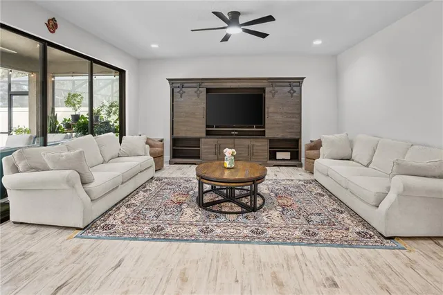 a large white kitchen with center island and stainless steel appliances
