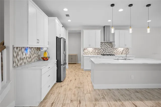 a view of kitchen with sink and refrigerator