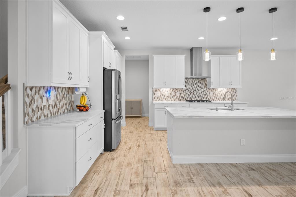 14654 Horse Trot Road Lithia, FL 33547 - Photo 15 of 53 a kitchen with stainless steel appliances granite countertop a refrigerator a oven and white cabinets with wooden floor