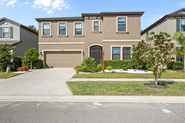 a front view of a house with a yard and a garage