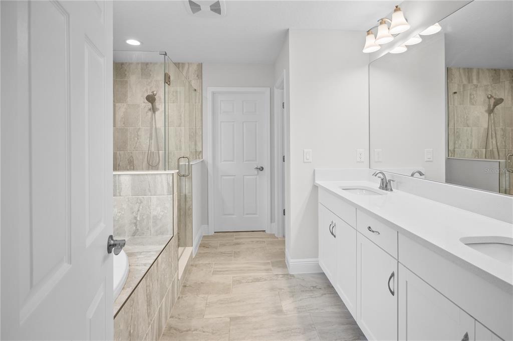 14654 Horse Trot Road Lithia, FL 33547 - Photo 32 of 53 a spacious bathroom with a double vanity sink a large mirror a shower and a bathtub