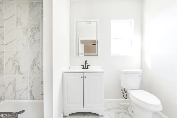 a bathroom with a sink a toilet and vanity