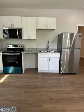 a kitchen with stainless steel appliances a stove a microwave and a refrigerator