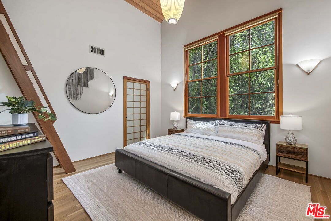 27 Latimer Road Santa Monica, CA 90402 - Photo 22 of 37 a bedroom with a bed a mirror and a window