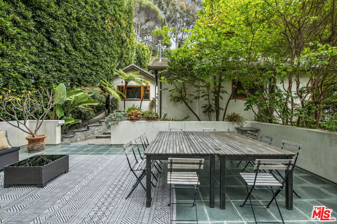 27 Latimer Road Santa Monica, CA 90402 - Photo 29 of 37 a view of a patio with table and chairs with wooden fence and plants