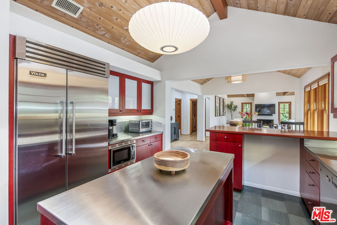 27 Latimer Road Santa Monica, CA 90402 - Photo 10 of 37 a kitchen with stainless steel appliances kitchen island granite countertop a refrigerator a stove and a sink with wooden floor