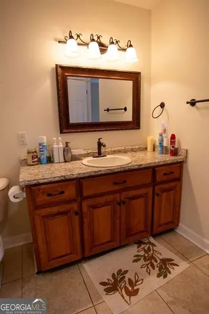 a bathroom with a granite countertop toilet sink and mirror