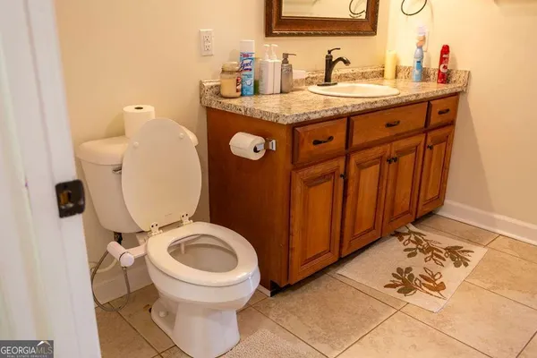 a bathroom with a toilet a sink and mirror