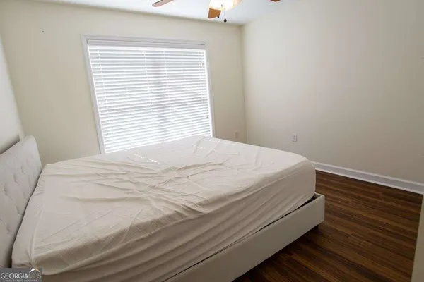 a bedroom with a bed and a chandelier fan