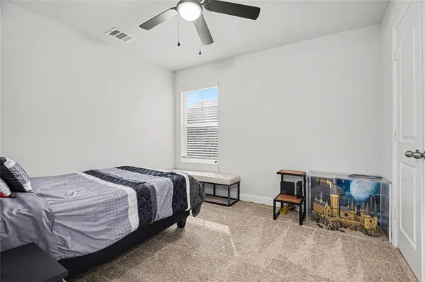 a bedroom with a bed a chair and a chandelier