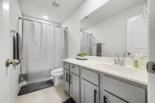 a bathroom with a double vanity sink toilet and shower