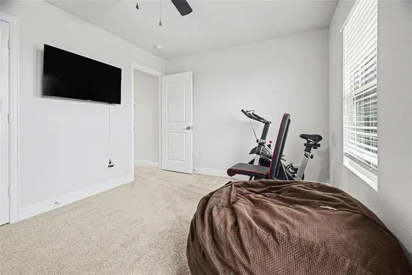 a bed room with a bed a television and a window
