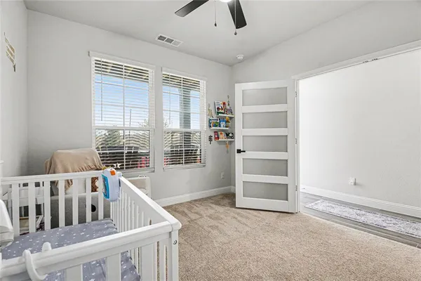 a view of an empty room with a window and a kitchen