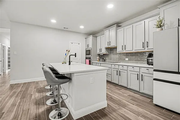 a kitchen with a sink cabinets and wooden floor