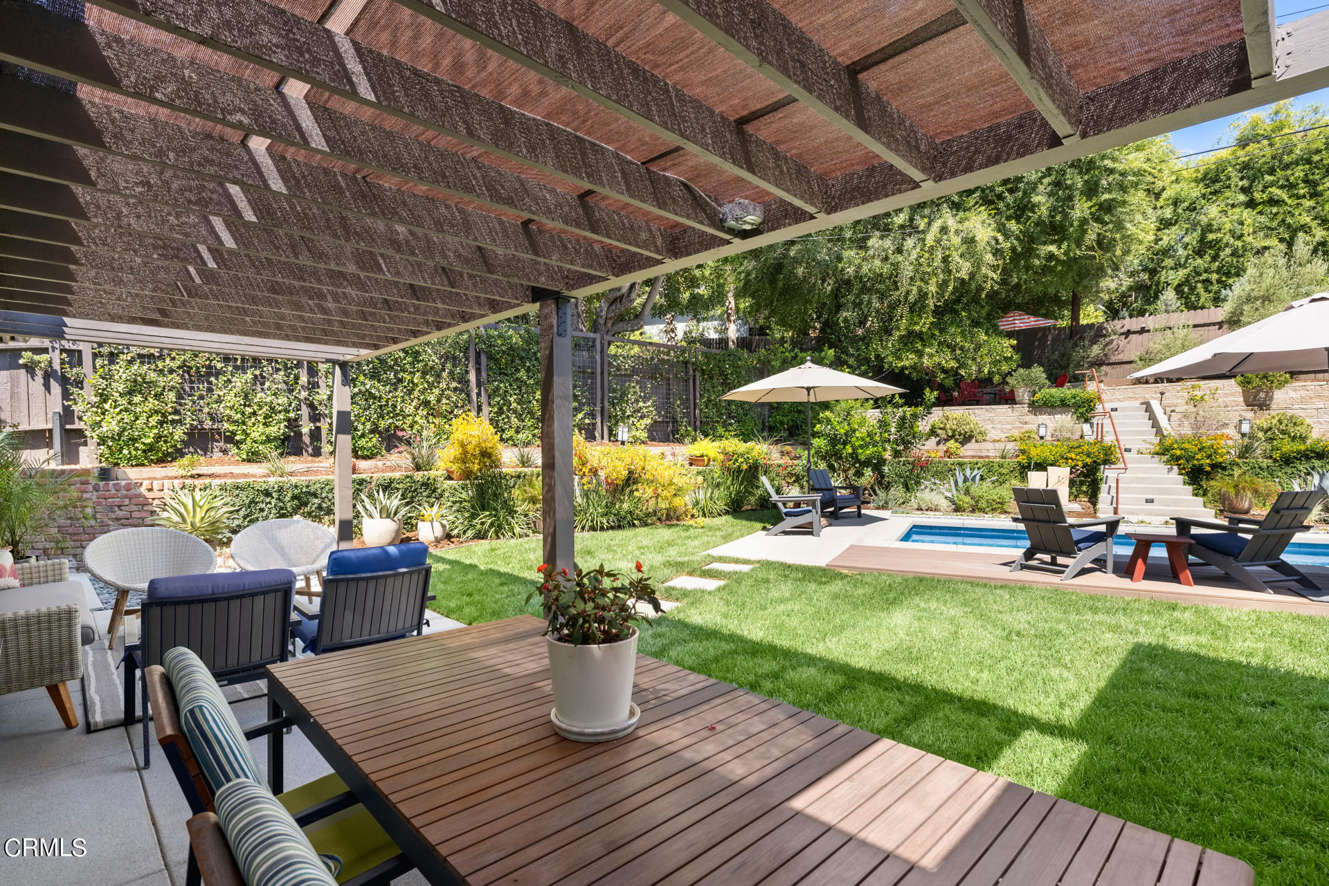 316 Glenullen Drive Pasadena, CA 91105 - Photo 32 of 43 a view of a patio with table and chairs potted plants and palm trees