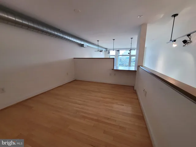 a view of empty room with wooden floor