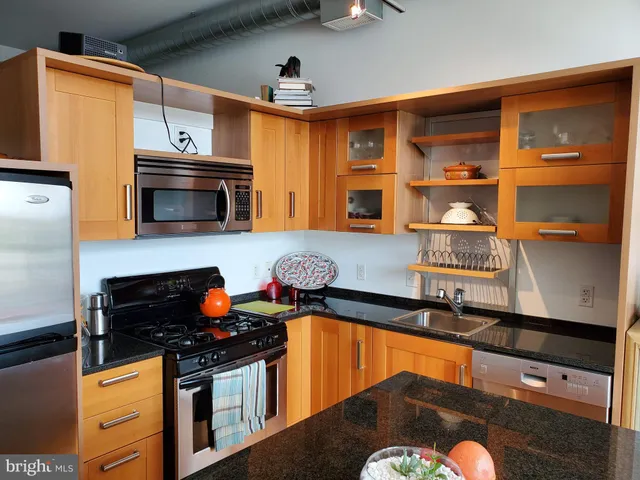 a kitchen with stainless steel appliances granite countertop a stove and a microwave