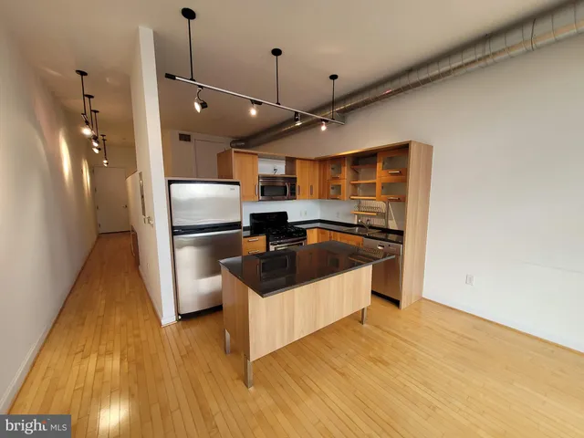 a kitchen with granite countertop a sink and refrigerator