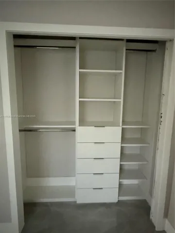 a view of walk in closet with empty racks